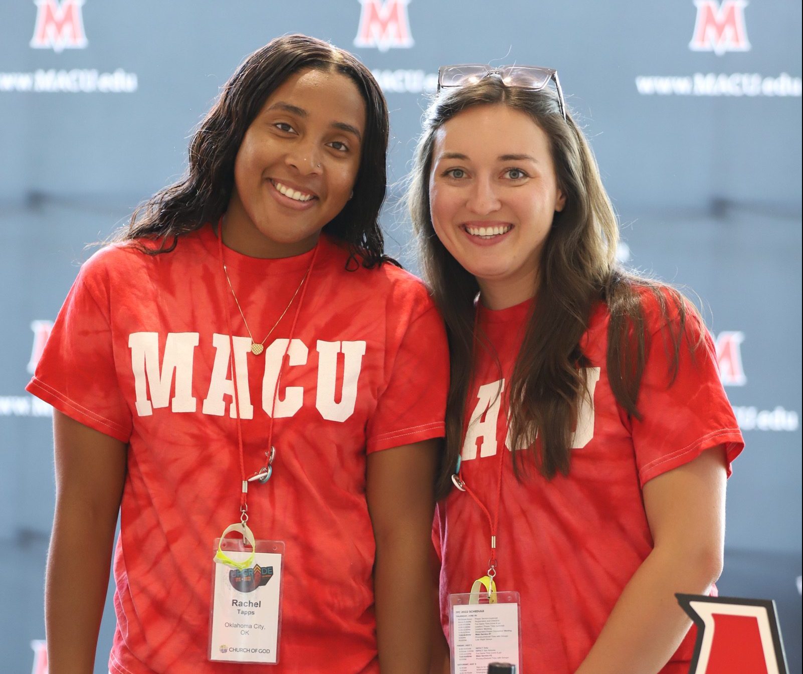 Two female students in red MACU T-shirts