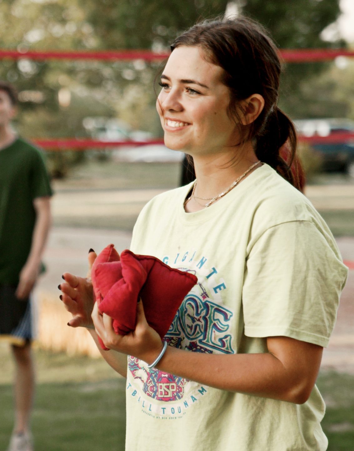 Girl in yellow shirt, smiling while playing a campus game