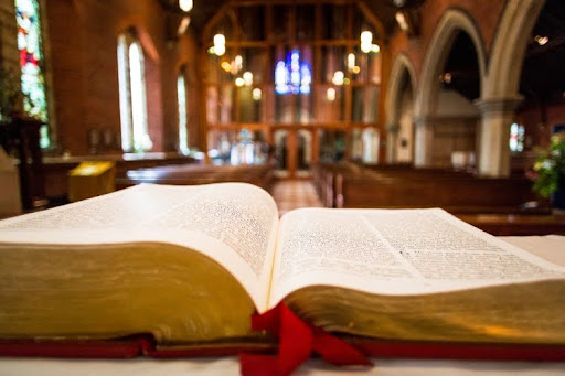 A Bible sitting on a table at the front of a church.