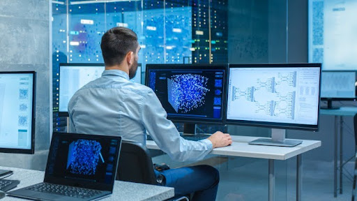 A data analyst working on computer monitors.