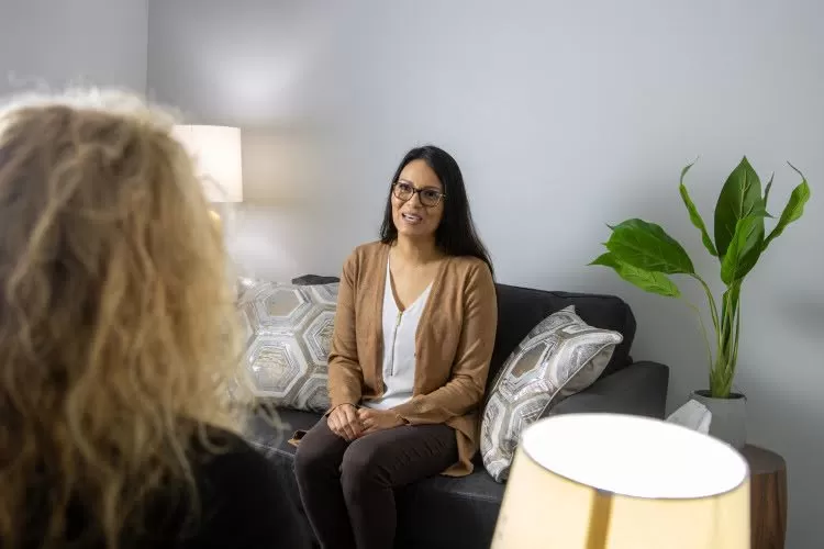 A counselor talking to a patient in an office.